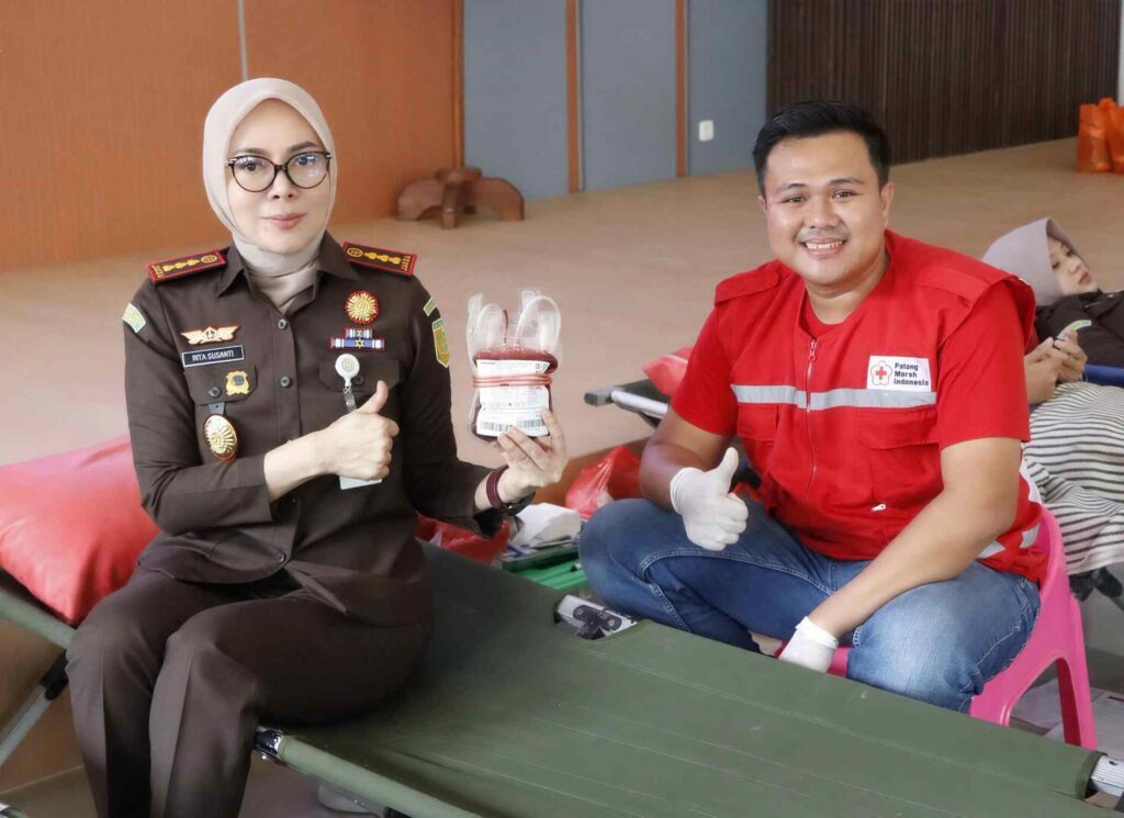 Harlah Kejaksaan ke-81, Kejari Lampung Tengah Hadirkan Bakti Sosial untuk Masyarakat Rangkaian tersebut dimaknai bukan sekadar sebagai perayaan perjalanan institusi, tetapi sebagai momentum untuk menghadirkan manfaat secara langsung, mempererat silaturahmi, serta membangun sinergi dengan berbagai unsur dalam semangat kepedulian terhadap sesama. Donor darah dan pemeriksaan kesehatan gratis dilaksanakan di Aula Kantor Kejaksaan Negeri Lampung Tengah dengan melibatkan Palang Merah Indonesia (PMI) Lampung Tengah dan tenaga kesehatan. Para peserta donor terlebih dahulu menjalani pemeriksaan dan skrining kesehatan untuk memastikan kelayakan sebelum melakukan donor darah. Antusiasme peserta dari berbagai unsur menjadi wujud solidaritas dalam mendukung ketersediaan darah bagi mereka yang membutuhkan. Sebanyak 52 peserta tercatat mengikuti proses skrining donor darah, sebagai bagian dari partisipasi dalam aksi kemanusiaan tersebut. Pada kesempatan yang sama, peserta memperoleh layanan pemeriksaan kesehatan gratis berupa pengecekan tekanan darah, berat badan, gula darah, dan asam urat, serta konsultasi kesehatan bersama tenaga medis. Kepala Kejaksaan Negeri Lampung Tengah, Dr. Rita Susanti, S.H., M.H., menyampaikan bahwa pengabdian kepada bangsa dan negara perlu berjalan seiring dengan kepedulian terhadap sesama. “Mendonorkan darah merupakan bentuk pengabdian yang sederhana, namun memiliki makna yang besar. Dari apa yang kita berikan hari ini, tumbuh harapan bagi mereka yang membutuhkan untuk melanjutkan kehidupan.” Menurutnya, Hari Lahir Kejaksaan hendaknya menjadi pengingat bahwa keberadaan institusi harus senantiasa memberikan manfaat, tidak hanya melalui pelaksanaan tugas dan kewenangan, tetapi juga melalui aksi nyata yang menyentuh kehidupan masyarakat. Rangkaian bakti sosial kemudian dilanjutkan dengan kunjungan kepada para Purnaja Kejaksaan. Kehadiran jajaran Kejaksaan menjadi bentuk penghormatan dan penghargaan atas dedikasi para pendahulu yang telah memberikan tenaga, pikiran, dan pengabdian dalam perjalanan panjang institusi Adhyaksa. Silaturahmi tersebut sekaligus mempererat ikatan kekeluargaan antara generasi yang meneruskan tugas dengan para Purnaja, serta menjadi pengingat bahwa setiap langkah institusi hari ini tidak terlepas dari jejak pengabdian generasi sebelumnya. “Apa yang kita jalankan hari ini tidak terlepas dari jejak pengabdian para pendahulu. Karena itu, menjaga silaturahmi dengan para Purnaja merupakan bentuk penghormatan sekaligus pengingat bagi kami untuk terus menjaga nilai-nilai pengabdian,” ujar Dr. Rita Susanti. Semangat berbagi selanjutnya diwujudkan melalui kunjungan sosial ke Panti Asuhan Al Marhamah. Jajaran Kejaksaan hadir untuk bersilaturahmi, berbagi perhatian, serta memberikan dukungan dan kebahagiaan kepada anak-anak panti. Kunjungan tersebut menjadi cerminan bahwa pengabdian memiliki makna yang luas. Kehadiran institusi tidak hanya diwujudkan melalui pelaksanaan tugas, tetapi juga melalui perhatian, kebersamaan, dan kepedulian yang mampu memberikan arti bagi kehidupan sesama. Rangkaian bakti sosial tersebut mendapat dukungan dan partisipasi dari berbagai pihak, di antaranya Pemerintah Kabupaten Lampung Tengah, TNI-Polri, PMI Lampung Tengah, tenaga kesehatan, jajaran Kejaksaan Negeri Lampung Tengah, Ikatan Adhyaksa Dharmakarini (IAD) Daerah Lampung Tengah, para Purnaja, serta berbagai unsur masyarakat lainnya. Sinergi tersebut menunjukkan bahwa semangat kemanusiaan dapat menjadi titik temu berbagai elemen untuk bergerak bersama. Darah yang didonasikan, kesehatan yang diperhatikan, silaturahmi yang dirawat, serta perhatian yang diberikan kepada anak-anak panti menjadi bagian dari satu makna besar: pengabdian yang hadir dan memberi manfaat. Bagi Kejaksaan Negeri Lampung Tengah, peringatan Hari Lahir Kejaksaan ke-81 menjadi refleksi untuk terus membangun kepercayaan publik melalui pelaksanaan tugas yang profesional, berintegritas, humanis, dan berorientasi pada kemanfaatan. Sebab, pengabdian bukan semata tentang apa yang dikerjakan, tetapi tentang seberapa jauh kehadiran mampu memberikan arti bagi kehidupan orang lain. Setetes darah menjadi harapan. Silaturahmi menjadi penghormatan. Berbagi menjadi wujud pengabdian.(ela)