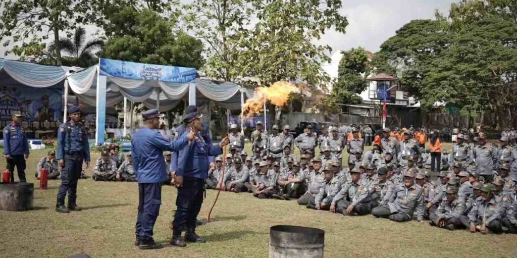 Satlinmas Bandar Lampung Digembleng, Dari Pelatihan Damkar hingga Penanggulangan Bencana 1 Satlinmas Bandar Lampung Digembleng, Dari Pelatihan Damkar hingga Penanggulangan Bencana Dalam kegiatan tersebut, anggota Satlinmas mendapat pelatihan pemadam kebakaran dari Dinas Pemadam Kebakaran dan Penyelamatan. Peserta tidak hanya diberikan pemahaman mengenai kebakaran, tetapi juga dibekali langkah-langkah awal yang harus dilakukan ketika menghadapi kejadian tersebut. Materi mencakup tindakan keselamatan dan penanganan awal sebelum kebakaran mendapatkan penanganan lebih lanjut dari petugas pemadam kebakaran. Pelatihan kemudian berlanjut pada materi penanggulangan bencana yang diberikan Badan Penanggulangan Bencana Daerah (BPBD). Anggota Satlinmas dibekali pengetahuan mengenai kesiapsiagaan, mitigasi, serta langkah yang perlu dilakukan ketika terjadi bencana atau keadaan darurat di lingkungan masyarakat. Pembekalan tersebut menjadi penting karena Satlinmas merupakan salah satu unsur yang berada dekat dengan masyarakat. Kemampuan mengenali situasi dan mengambil langkah awal diharapkan dapat membantu ketika terjadi kondisi darurat sebelum penanganan dilakukan oleh instansi terkait. Selain pelatihan Damkar dan kebencanaan, anggota Satlinmas juga mengikuti pelatihan kepramukaan. Materi ini diarahkan untuk membangun kedisiplinan, kerja sama, kepemimpinan dan kemampuan anggota dalam menjalankan tugas di lapangan. Rangkaian pelatihan tersebut menjadi bagian dari upaya meningkatkan kapasitas dan kesiapsiagaan anggota Satlinmas Bhakti Karya Kota Bandar Lampung. Dengan pembekalan tersebut, anggota Satlinmas diharapkan semakin siap menghadapi berbagai kondisi darurat serta mampu memberikan respons awal yang tepat ketika masyarakat membutuhkan bantuan.